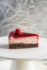 piece of cake with cream and berries on a white plate