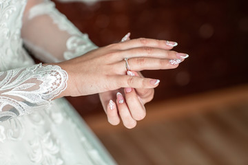 Wedding ring with stone. hands of a bride with a ring and a wedding manicure