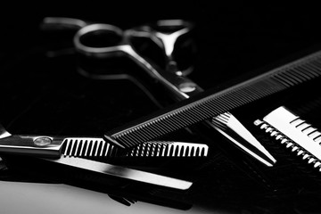 Scissors, comb and razor for hair. Barber tool close-up on a dark background. Hairdresser tool.