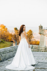 Obraz premium Cute redheaded bride stands on the balcony of an old castle