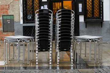 Stacked chairs and tables outside a caf�, Cuenca, Cuenca Province, Castilla La Mancha, Spain