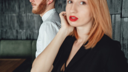 A young woman and her boyfriend are posing for the camera indoors.