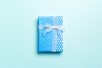 Top view Christmas present box with white bow on blue background with copy space