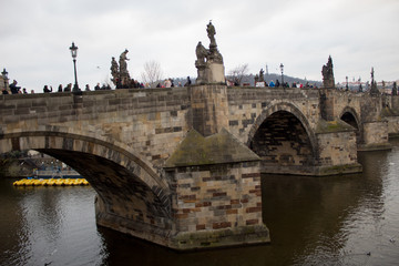 Fototapeta na wymiar The main attraction of the Czech capital city of Prague is the Charles Bridge on Christmas Eve with many tourists and a view of the Vltava River.