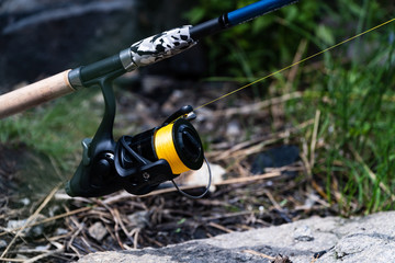 Outdoor shot of modern feeder fishing reel in black color - 310432447