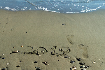 Number 2019 and footprints on sand
