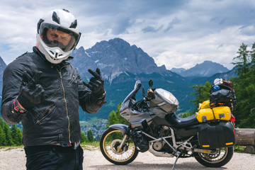 Close up portrait of happy biker man in helmet and stylish leather jacket. Adventure touring...