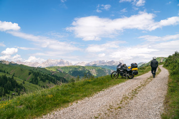 Motorcycle rider enjoy the momment. Touring adventure motorbike on the top of mountain, enduro, off road, beautiful view, danger road, freedom, extreme vacation. Copy space. Passo Pordoi, Italy