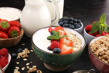 Tasty homemade granola served on table. Healthy breakfast with a bowl of oatmeal with banana, blueberries, strawberries and healthy food for Breakfast