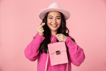 Image of asian girl in hat showing money counting gesture and holding bag