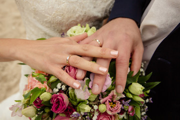 schöne Hände mit Eheringen und Brautstrauss