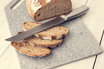 Fresh fragrant bread on a kitchen cutting board made of artificial stone