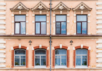 Fototapeta na wymiar Several windows in a row on the facade of the urban historic building front view, Vyborg, Leningrad Oblast, Russia