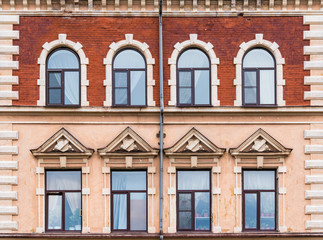 Fototapeta na wymiar Several windows in a row on the facade of the urban historic building front view, Vyborg, Leningrad Oblast, Russia