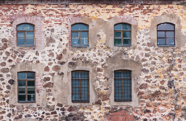 Fototapeta na wymiar Several windows in a row in the stone wall of the Vyborg Castle front view, Vyborg, Leningrad Oblast, Russia