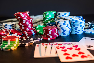 Poker chips and playing card on black table