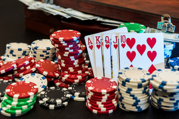 Poker chips and playing card on black table