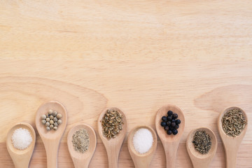 Various spices in wooden spoon on wood table background