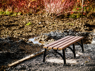 Metal bench installed, park renovation. Ground work in progress. Selective focus.
