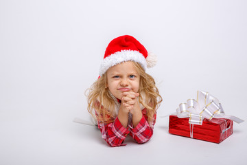 little girl in Santa hat lying on white background isolated on white background