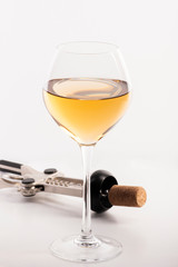 High angle view with shallow depth of field of a glass of white wine with a corkscrew.