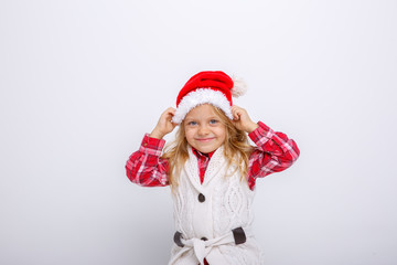 cute happy little girl in santa claus hat. Santa's assistant smiles on a white background