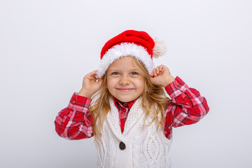 cute happy little girl in santa claus hat. Santa's assistant smiles on a white background