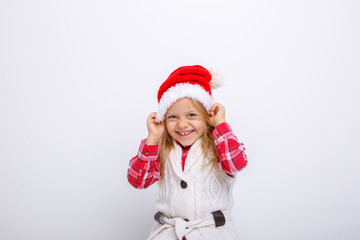 cute happy little girl in santa claus hat. Santa's assistant smiles on a white background