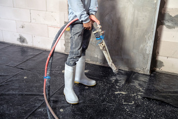 Construction workers holding cement spraying lines