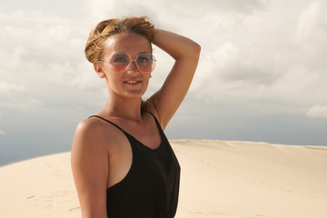 The girl in black dress posing in the desert