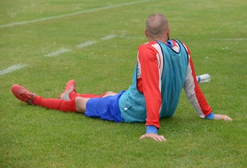 Le joueur de football assis en attente