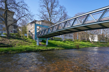 Iron bridge over a small river for pedestrians against the blue sky in a European city, in spring. Clean City Concept, text space