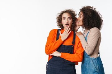 Portrait of african american woman whispering to surprised girl