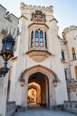 Entrance to a tall old castle with a lantern on the wall and a large window