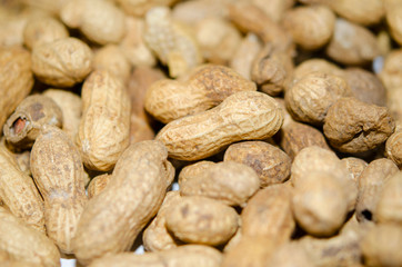 Unshelled peanuts close-up. Lots of nuts, vegan, natural food.