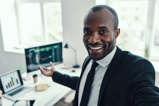 Self Portrait Of Happy Young African Man In Formalwear Looking At Camera And Smiling While Working In The Office