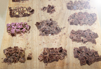 Raw chocolate pieces with nuts. Natural chocolate on wooden background.