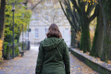 Spaziergang in Detmold - eine junge Frau in einem grünen Mantel geht im Herbst spazieren. Den...