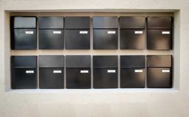 viele Braune Briefkästen hängen in zwei Reihen an einer Wand