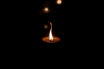 Candle on the tombstone, the feast of the dead, All Saints' Day by night with bokeh colorful...