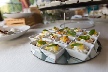 Tavolata con antipasti in contenitori bianchi