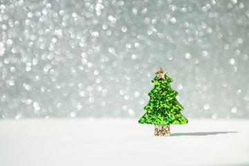Shiny green glitter Christmas tree over blurred shiny silver bokeh background, decorate item, shiny festive season and holiday