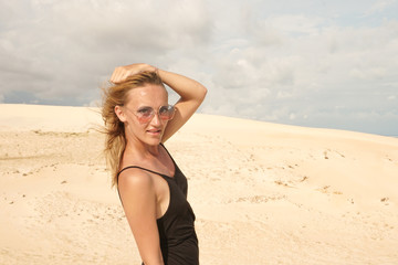 The girl in black dress posing in the desert