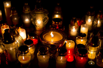 A lot of candles snitch on the tombstone, the feast of the dead,, All Saints' Day by night. Colorful background. Mourning, Funeral
