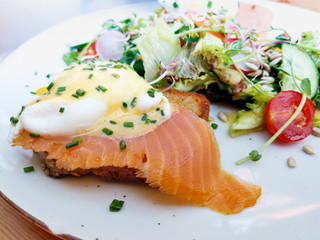 Tasty homemade omelette with fresh salmon served with lettuce on top in white ceramic vintage plate
