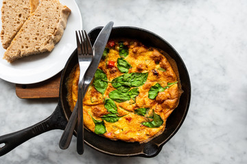 Delicious homemade omelet with vegetables cooked in oven and served in a traditional pan