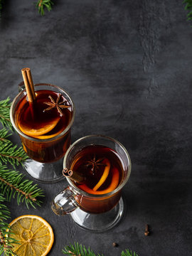 Non Alcoholic Mulled Wine (gluhwein) With Orange Slices , Anise Stars, Spices And Cinnamon Sticks On Dark Background With Spruse Branches. Christmas And New Year Flat Layout. Top View Drinks.