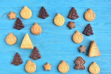 Fototapeta na wymiar Set of cute homemade gingerbread cookies for christmas on wooden blue background. New year biscuits with beautiful iced decoration on textured turquoise backdrop. Traditional gingerbread cookies 