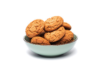 fresh tasty oatmeal cookies in a turquoise plate on a white background