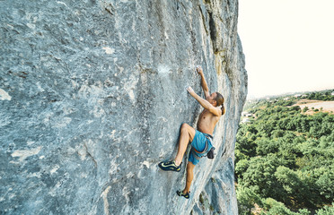 muscular man rockclimber with naked torso climbing on tough sport route. outdoors rock climbing and active lifestyle concept, climbing moments